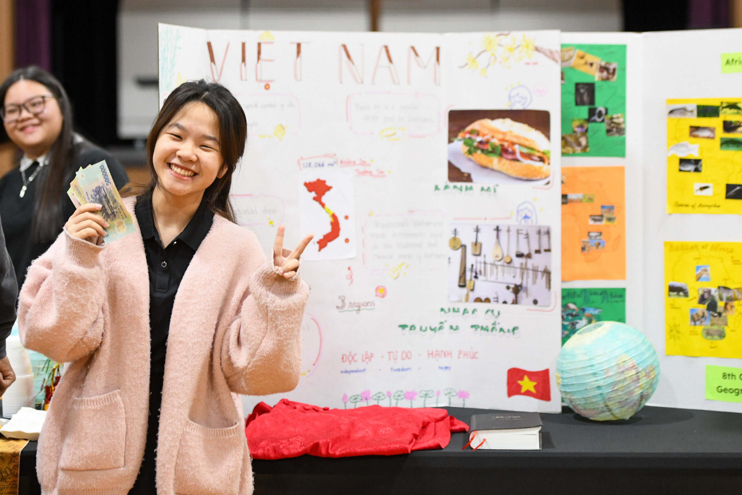 A student standing in front of her science project at the science fair.